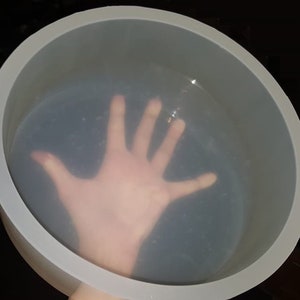Könnte beinhalten: Eine große, transparente, runde Silikonform zum Backen oder Basteln. Die Form ist flexibel und hat eine glatte, glänzende Oberfläche.