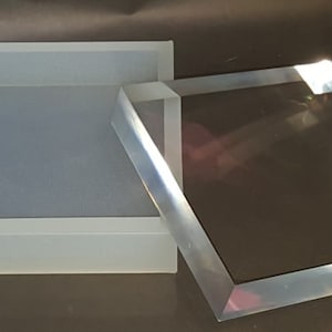 May include: A clear rectangular silicone mold and a clear acrylic block, both with a square shape.