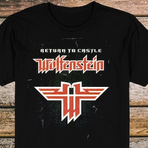 May include: Black t-shirt featuring the text "RETURN TO CASTLE WOLFENSTEIN" in white and red. Below the text is a red and white graphic design. The shirt is made of a soft material.