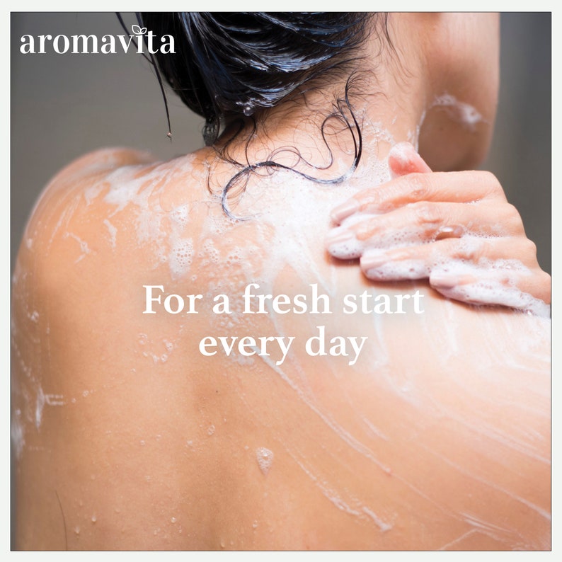 A woman enjoying a refreshing shower, with soap lather on her back. The image highlights Aromavita’s PureDefend Soap, designed for everyday use, offering a gentle cleanse, deep hydration, and long-lasting freshness with natural ingredients.