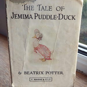 May include: The Tale of Jemima Puddle-Duck by Beatrix Potter, a vintage children's book with a cover illustration of a duck wearing a pink dress and a bonnet.