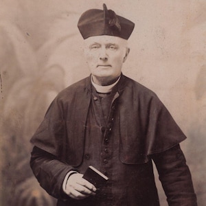 Foto original de la década de 1890 de un sacerdote sosteniendo una Biblia en su gabinete. Retrato antiguo de un hombre de la época victoriana eduardiana, Manchester, Inglaterra.
