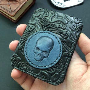 ミニマルなブラックのウォレット/カードホルダー。ブルーのスカルがエンボス加工されています。シェリダンスタイルのテクスチャードレザーを使用。高品質、ハンドメイド。ユニセックスギフト。