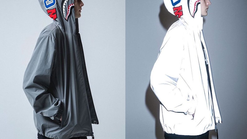 May include: Two hooded jackets, one gray and one white, with a shark graphic on the hood. Both jackets have a zipper closure and a drawstring at the waist.