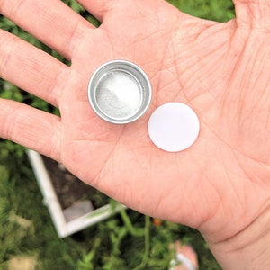 close up of the metal cap and the foam lining you will need to pop out with a small sharp object before recycling, my garden is in the background