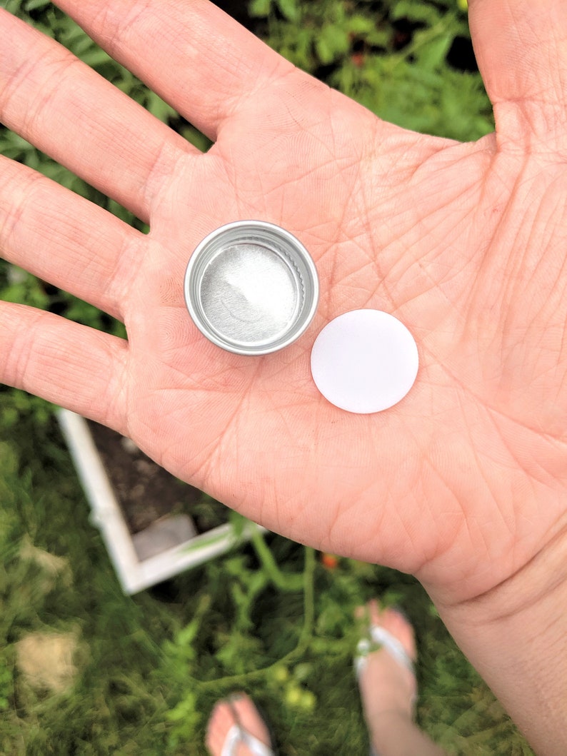 close up of the metal cap and the foam lining you will need to pop out with a small sharp object before recycling, my garden is in the background