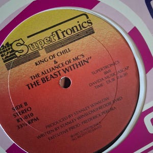 May include: A circular vinyl record label with a yellow-to-red gradient background. It features the text SuperTronics, King of Chill & The Alliance of MC's, The Beast Within, Side B, Stereo, RY-010, 33 1/3 RPM, and production credits from 1985.
