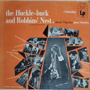 May include: Vintage vinyl record album cover for "The Huckle-buck and Robbins' Nest" by Buck Clayton. The cover is orange with black and white images of musicians. The album title and artist name are prominently displayed.