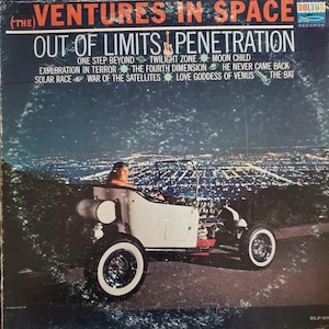 May include: Vintage vinyl record album cover for "The Ventures in Space." The album cover features a white hot rod with a person driving, set against a nighttime cityscape. The album title and track names are displayed at the top.