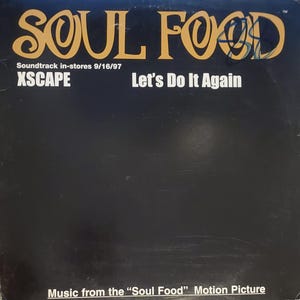 May include: A black and white album cover with the title "SOUL FOOD" in large, stylized yellow letters. The text "Soundtrack in-stores 9/16/97" and "XSCAPE" are in smaller white letters. The text "Let's Do It Again" is in white letters. The text "Music from the "Soul Food" Motion Picture" is in white letters at the bottom of the cover.