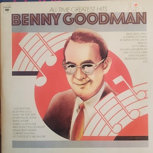 May include: A vintage vinyl record album cover for "All-Time Greatest Hits" by Benny Goodman. The cover features a portrait of Goodman wearing glasses and a tie, set against a red and white background with musical notes. Song titles are listed on the sides.