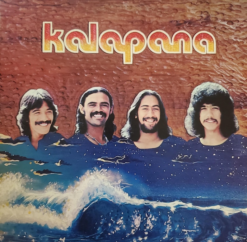 May include: Album cover for Kalapana, featuring the band members above a painted ocean scene. The band's name is in orange and yellow lettering. The image has a retro aesthetic.