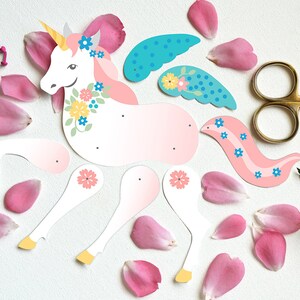 May include: A paper craft kit to make a unicorn with pink, white, and blue details. The kit includes a unicorn body, wings, and a tail. The unicorn has a flower crown and a horn.