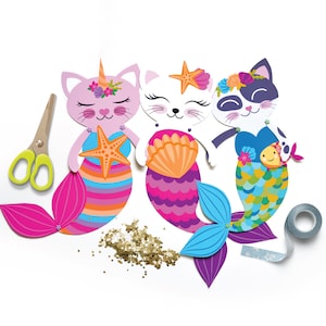 May include: Three paper cat mermaid crafts with colorful tails and glitter. The mermaids are wearing seashells and holding starfish.