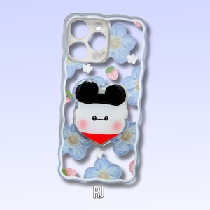 May include: Clear phone case with a cartoon character design. The case features a white and black character with a red heart-shaped collar, surrounded by blue floral and strawberry designs. The initials "RJ" are at the bottom.