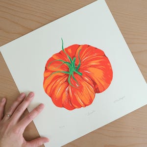 May include: A close-up of a red and orange tomato with a green stem. The tomato is depicted in a stylized, almost cartoon-like way. The print is titled "Tomato" and signed "Melissa Meyer".