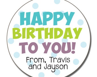 May include: A round sticker with a white background and blue polka dots. The text "Happy Birthday to You!" is written in large, colorful letters. The text "From, Travis and Jayson" is written in smaller black letters at the bottom.