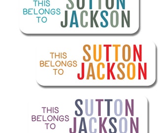 Puede incluir: Tres etiquetas rectangulares blancas con esquinas redondeadas. Cada etiqueta tiene el texto "THIS BELONGS TO" en negro. El texto "SUTTON JACKSON" está en letras apiladas de colores. La primera etiqueta tiene letras azul turquesa, grises y azules. La segunda etiqueta tiene letras naranja, rojas y amarillas. La tercera etiqueta tiene letras moradas, grises y azules.