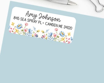 May include: A white address label with a floral border. The label has the text "Amy Johnson", "845 Sea Spray Pl.", "Camden ME 34120" printed in black.