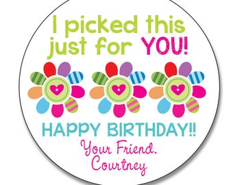 May include: A round sticker with a white background features the text "I picked this just for YOU!" in green and pink. Below are three colorful flower designs with heart centers. The words "HAPPY BIRTHDAY!!" and "Your Friend, Courtney" are also included.