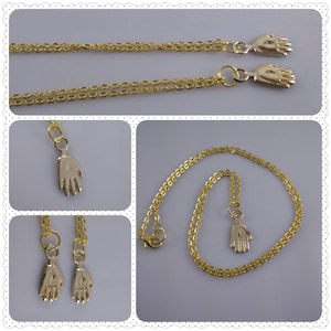 Peut inclure: Colliers dorés avec des pendentifs en forme de main. Les colliers ont des maillons de chaîne délicats et une fermeture à fermoir mousqueton. Les pendentifs en forme de main sont détaillés avec des doigts individuels et une finition lisse.