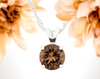May include: A silver chain necklace with a brown gemstone pendant. The pendant is round and has a faceted cut.