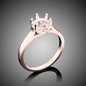 May include: A rose gold ring setting with a round center stone setting. The ring has a simple band and a six-prong setting.