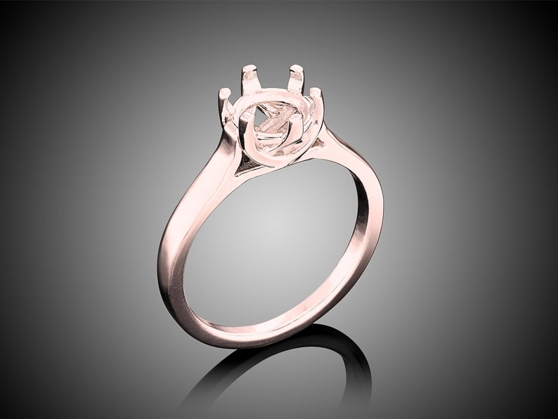 May include: A rose gold ring setting with a round center stone setting. The ring has a simple band and a six-prong setting.
