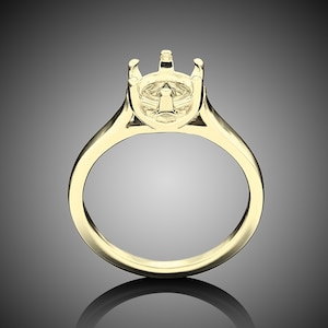 May include: A gold ring setting with a prong setting for a center stone.