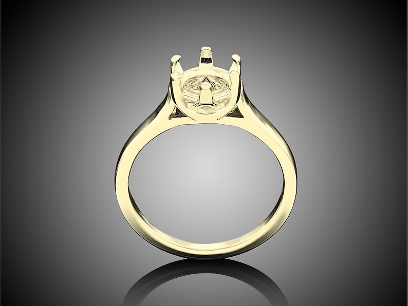 May include: A gold ring setting with a prong setting for a center stone.
