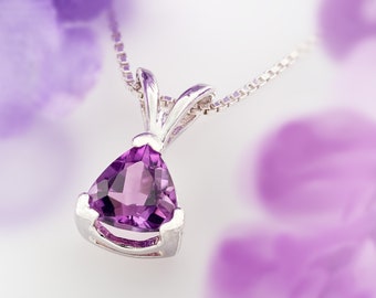 May include: A silver necklace with a triangular amethyst pendant. The pendant is set in a silver bezel and has a faceted cut.