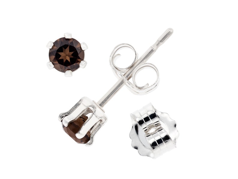 May include: A pair of silver stud earrings with brown gemstone accents. The earrings have a post and butterfly back.