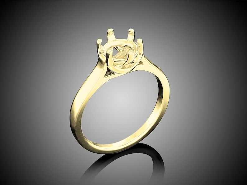 May include: A gold ring setting with a round center stone setting. The setting has six prongs and a smooth band.
