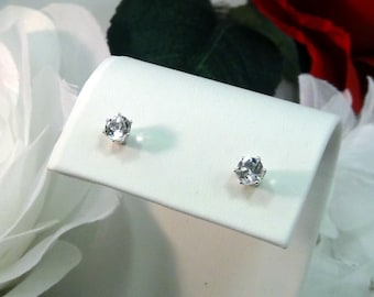 May include: A pair of silver stud earrings with clear round gemstones.