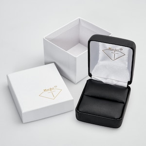 Estojo preto para anéis e caixa de presente MARILEI. Estojo preto para joias em couro sintético e caixa de papelão branca com logotipo dourado Marilei em relevo.
