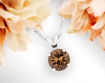 May include: A silver chain necklace with a brown gemstone pendant. The pendant is round and has a faceted design.