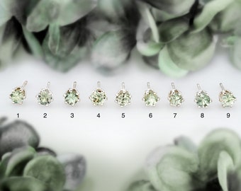 May include: Nine silver stud earrings with green gemstones, numbered 1 through 9.