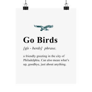 May include: A white poster with the text "Go Birds" in a bold, black font, accompanied by a green eagle graphic. The poster defines the phrase as a friendly greeting in Philadelphia, also meaning "what's up" or "goodbye."