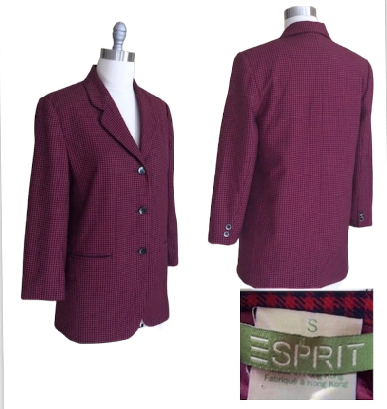 May include: A red and black checkered blazer with a single-breasted closure and three buttons. The blazer has a small pocket on the left side and is labeled "ESPRIT" in green with the size "S" in white. The label also says "Fabriqu&eacute; &agrave; Hong Kong".