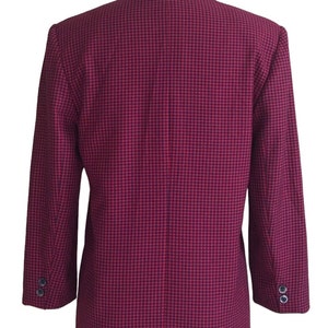 May include: A red and black checkered blazer with long sleeves and a single button closure. The blazer is on a white mannequin.