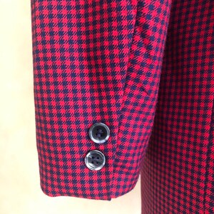 May include: Red and black gingham blazer with two black buttons on the sleeve.