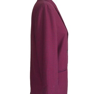 May include: A red and black checkered blazer with a double breasted closure and a single pocket on the left side.