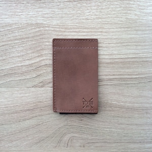 Cartera minimalista que combina cuero genuino con elástico.