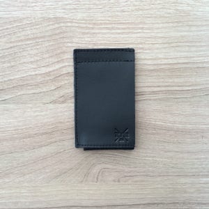 Cartera minimalista que combina cuero genuino con elástico.