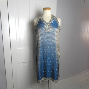 May include: A blue and white halter dress with a beaded neckline and a gradient design. The dress is sleeveless and has a loose fit.
