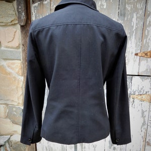 May include: A black blazer with a long sleeve and a button-up collar.