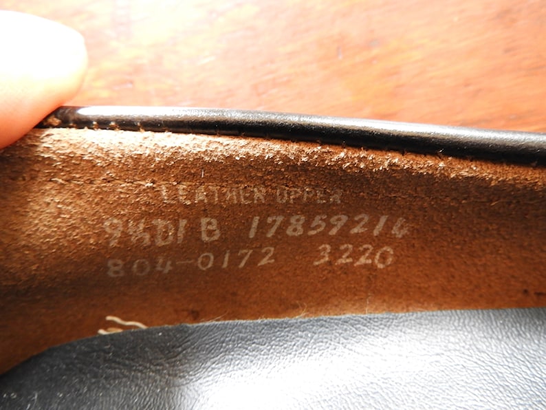May include: Close-up of the inside of a black leather shoe. The insole is brown leather with white text that reads "Leather Upper 94DI B 17859214 804-0172 3220".