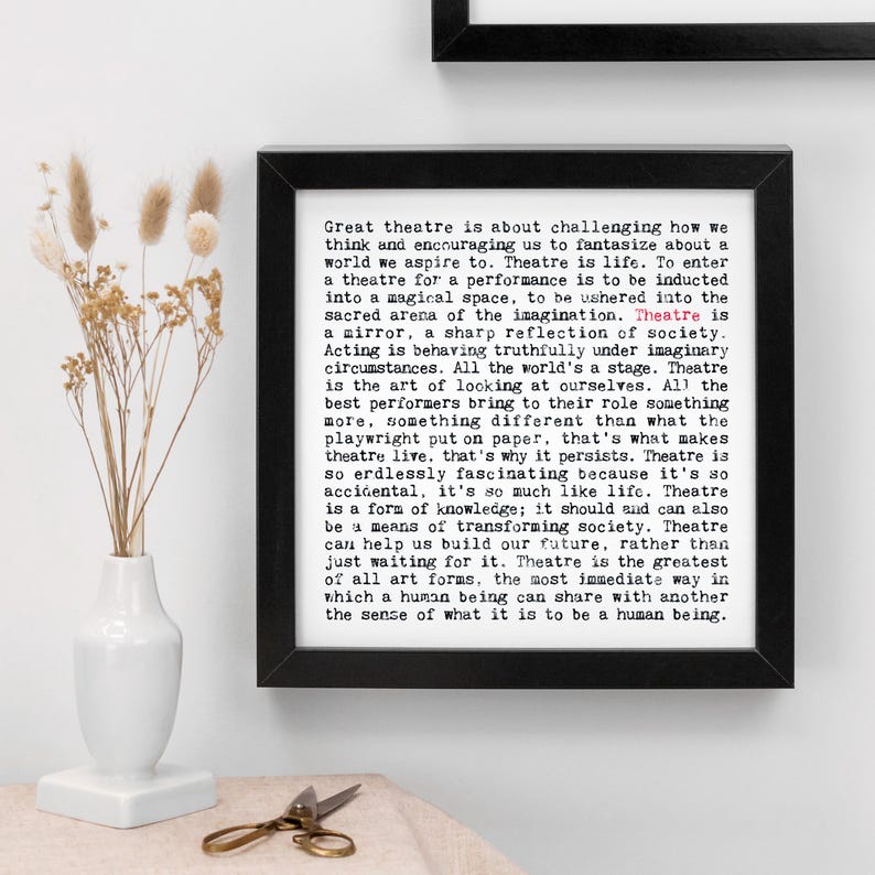 May include: A framed black and white print with the text "Great theatre is about challenging how we think and encouraging us to fantasize about a world we aspire to." The print is in a black frame.