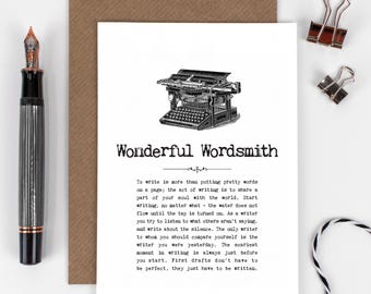 May include: A greeting card with the text "Wonderful Wordsmith" and a vintage typewriter illustration. A black and silver fountain pen and two silver binder clips are also visible.