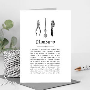 May include: A white card featuring the word "Plumbers" and drawings of plumbing tools. The card contains text about plumbers and their profession.